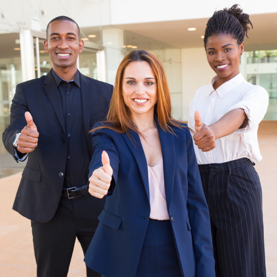 Optimistic young interracial business people showing thumbs-up