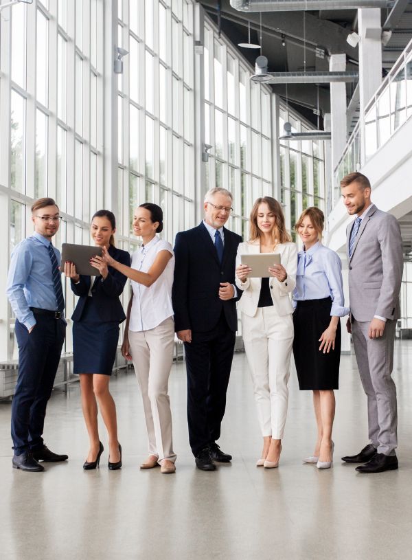 Contemplated young businesswoman sitting on chair holding clipboard and pen in her hand